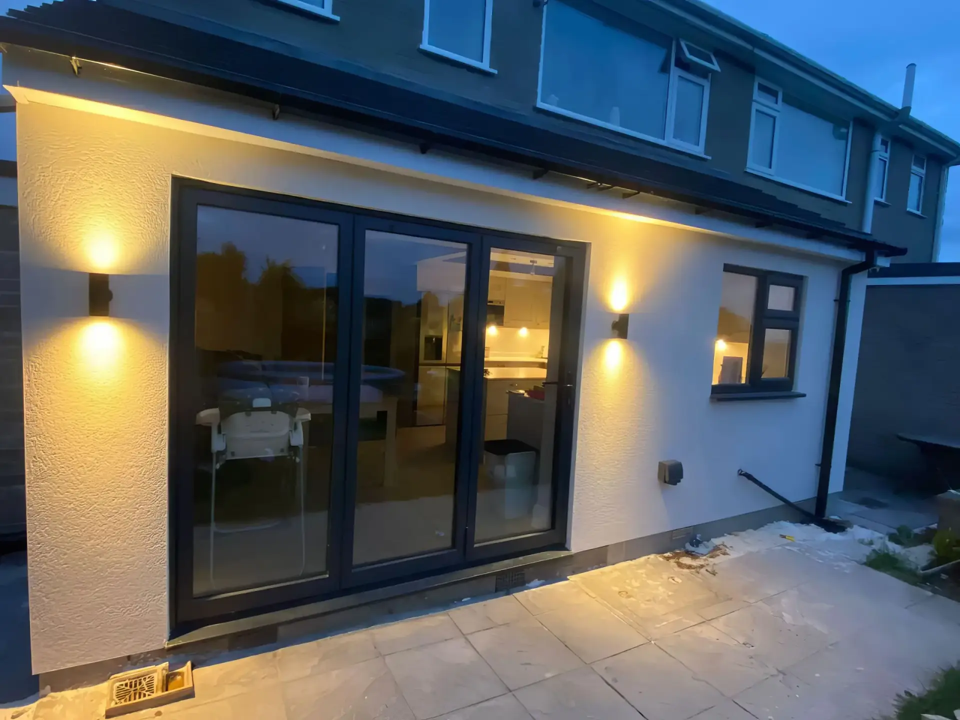 Completed home rendering project with exterior lights by Peak Plastering and Rendering, Sheffield, showcasing professional plastering and rendering services.